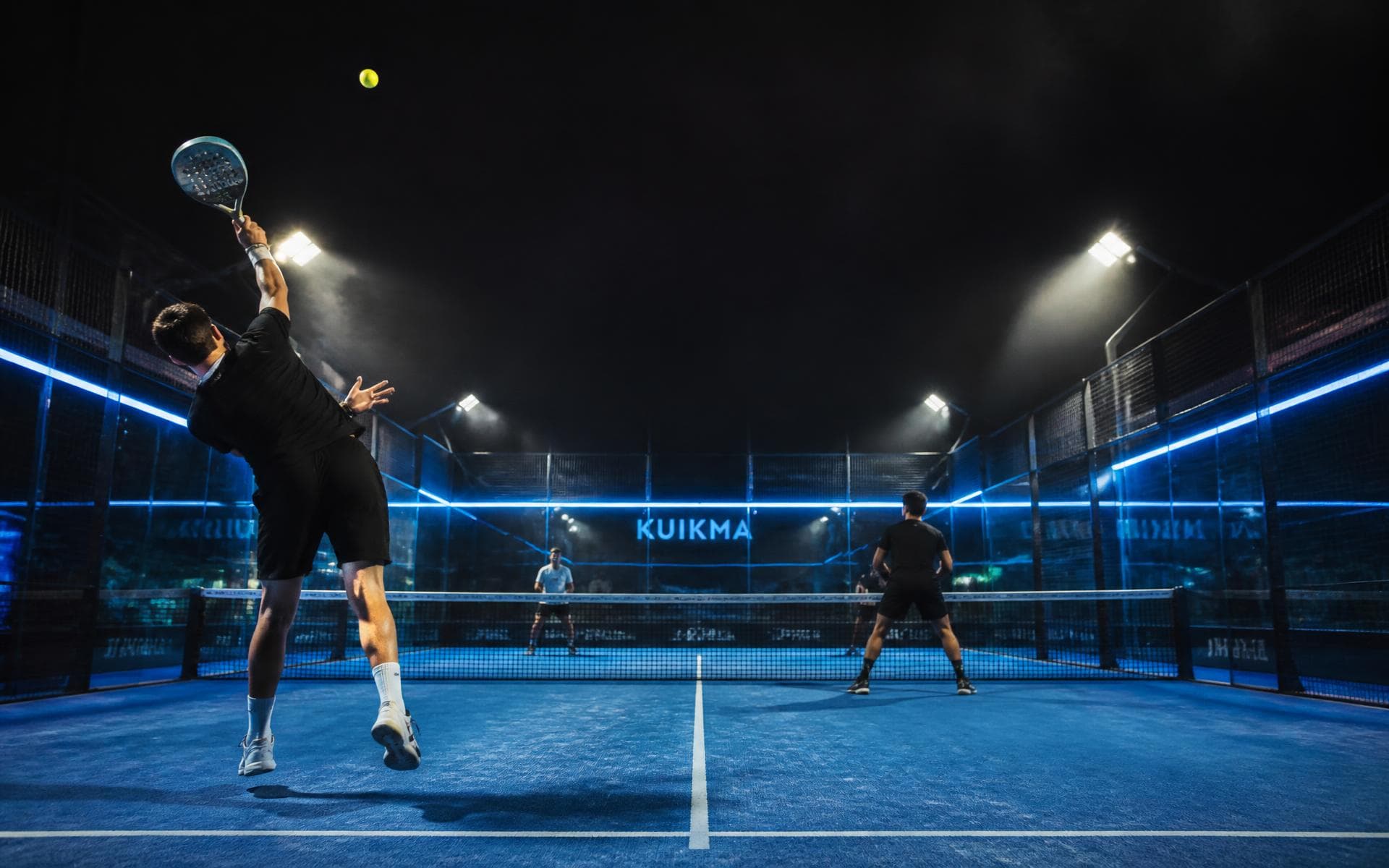 Neon-lit padel court at night, players mid-game